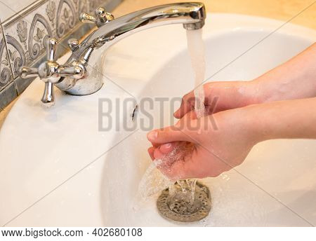 Teenager. Washing Hands In The Bathroom Sink. Frequent Hand Washing Is A Prerequisite For Good Hygie
