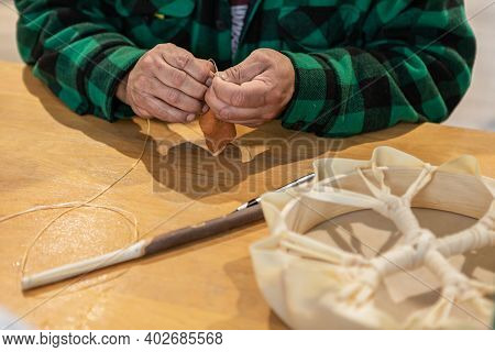 Close Up Of Mans Hands Roughly Sewing A Piece Of Leather To Create The Soft Head Of A Drum Stick, Du