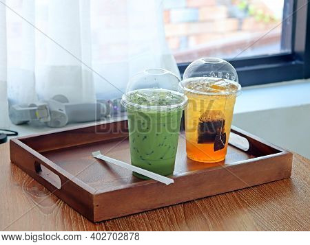 The Glass Of Ice Matcha Green Tea And Honey Lemon Tea On Wooden Table With See Through Curtains, Fee