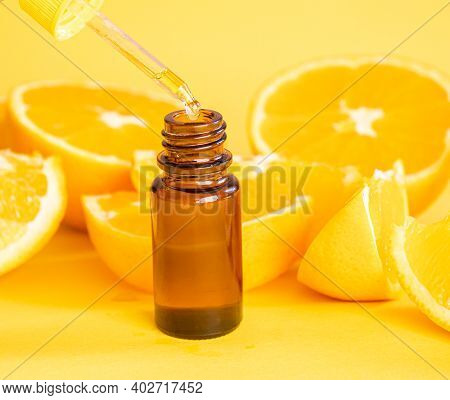 Orange Essential Oil On A Yellow Background. Selective Focus.