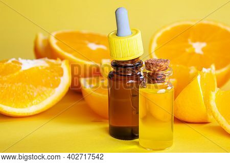 Orange Essential Oil On A Yellow Background. Selective Focus.