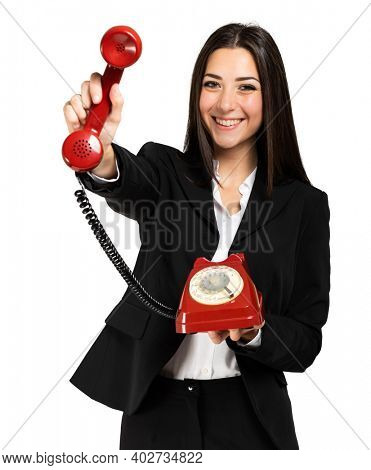 Young female manager holding a red vintage phone, contacs us concept