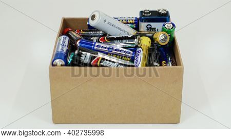 A Cardboard Box On A White Background Full Of Used Household Aa, Aaa, Pp3 Alkaline Batteries Collect