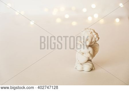 Figurine Of An Angel Cupid With A Bow On A Pink Background. Valentine's Day.