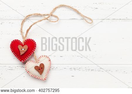 Valentines day greeting card template. Heart shaped decor over white wooden background. Top view flat lay with copy space