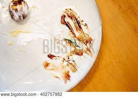 Finished Empty Dessert Plate With Spoon On Wood Table