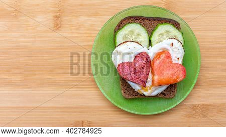 Cucumber Sandwich, Heart Shaped Scrambled Eggs With Sausages And Heart Shaped Tomato On A Green Plat