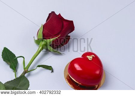 Red Rose And Modern French Mousse Dessert In Shape Of Heart On Blue Background Horizontal