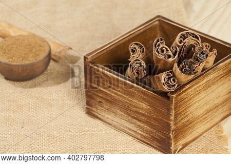 Cinnamon Powder And Cinnamon Stick; Photo On Wooden Background.