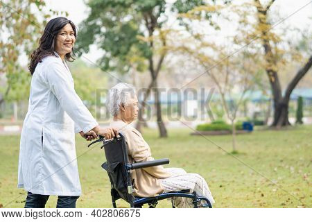 Doctor Help And Care Asian Senior Or Elderly Old Lady Woman Patient Sitting On Wheelchair At Park In