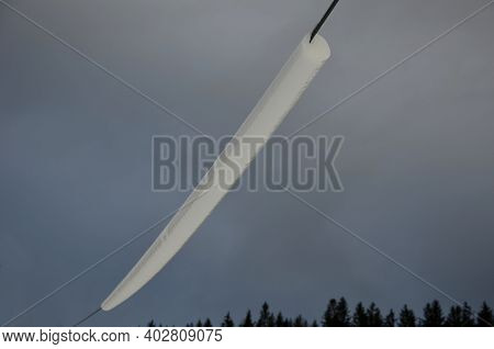 Power Lines Frozen By A Large Layer Of Ice In The Shape Of A Cylinder With Icicles. Icing Loads The 