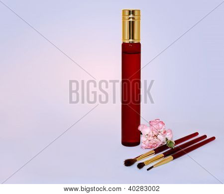 Bouteille de parfum, brosses pour maquillage et fleur