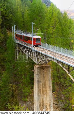Zermatt, Switzerland - October 7, 2019: Arriving Gornergrat Red Tourist Train Front View On The Brid