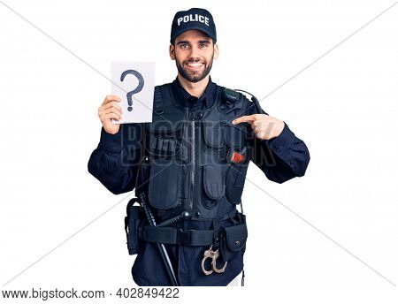 Young handsome man with beard wearing police uniform holding question mark pointing finger to one self smiling happy and proud 