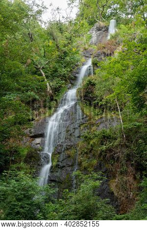 Long Exposure Of The Waterfall Flowing Over The Cliff At Canonteign Falls In Dartmoor