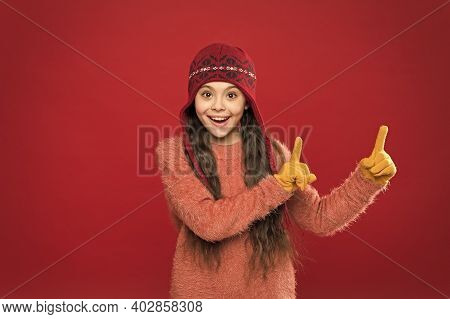 Lots Of Great Deals. Happy Child In Warm Hat Pointing Fingers At Something. Clearance Sale On Kids F