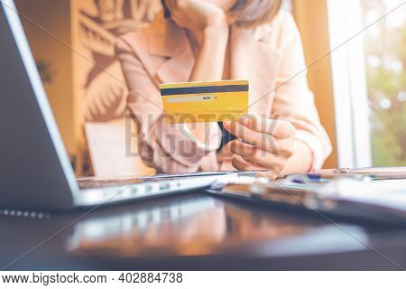 Business People Holding Credit Cards And Using Laptops Shopping Online.