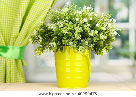 Dekorative blomster i puljen på vindueskarmen