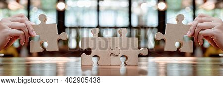 Businesswoman With Wooden Puzzle And Jigsaw For Business Succcess Concept. Teamwork And Achievement 