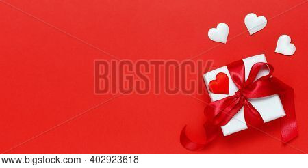 A White Gift Box Tied With A Red Ribbon On A Red Background For Valentine's Day, Birthday, Mother's 