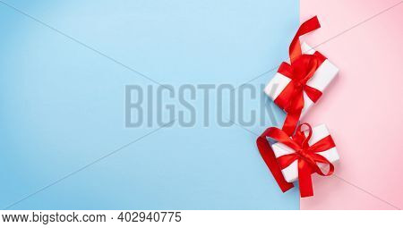 Valentines day greeting card template. Gift boxes over blue and pink background. Top view flat lay with copy space
