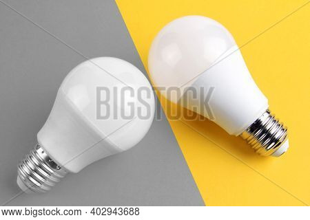 The Colors Of 2021 Are Gray And Yellow. Two Electric Incandescent Lamps In White Matte Color On A Ye