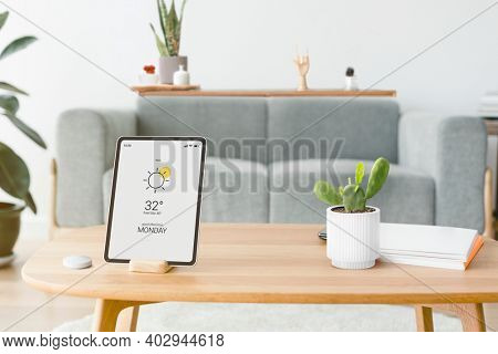 Digital tablet screen with a smart home controller on a wooden table