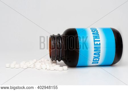 Dexamethasone Glass Bottle Packaging With Scattered Pills. Treatments For Covid-19. Isolated On Whit