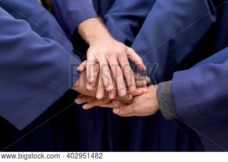 education, graduation and people concept - close up of inernational graduate students stacking hands