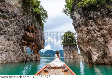Back View Of Young Female Tourist In Dress And Hat At Longtail Boat Near Famous Three Rocks With Lim