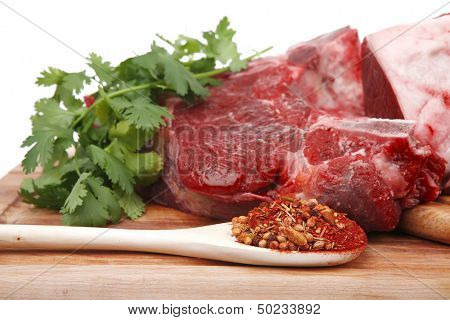 butchery : fresh raw beef lamb big rib and fillet ready to cooking with green stuff on wooden plate isolated over white background