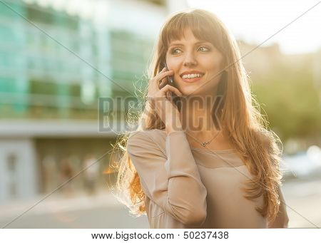 Sophisticated businesswoman in dress talking on the phone.