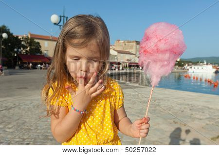 Pretty little girl eating candy floss