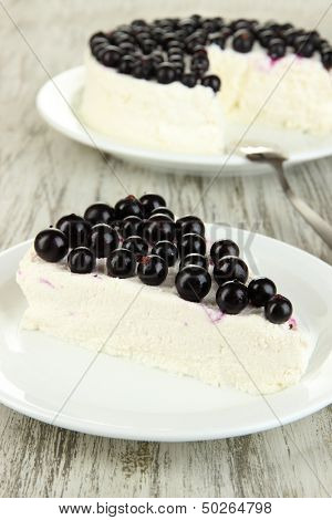 Cheesecake with fresh berries on white plate on wooden table closeup
