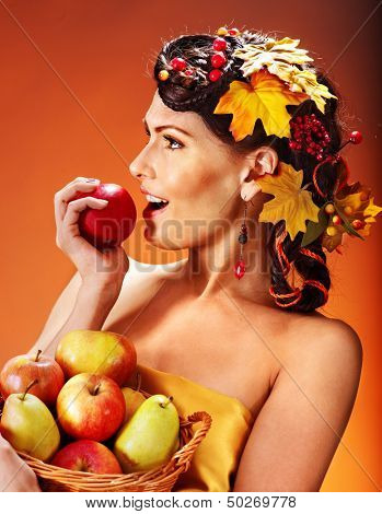 Woman holding autumn basket with fruit and vegetable.