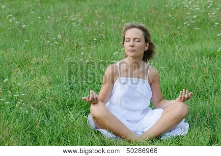young woman practicing yoga in nature