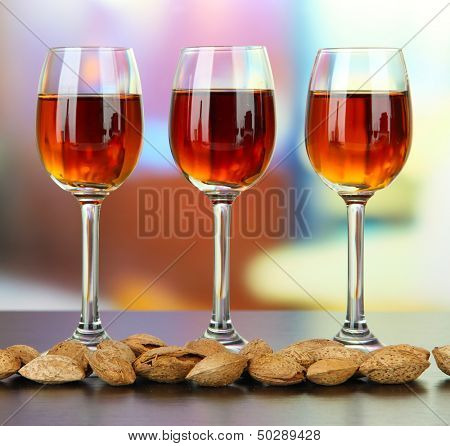 Sklenice likéru amaretto a pražených mandlí, na světlé pozadí