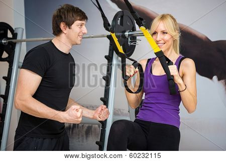 Personal trainer assist woman exercising on at gym 