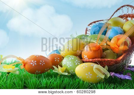 color easter eggs in basket against blue sky and clouds