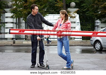 Happy Couple With Scooter Near The Barrier