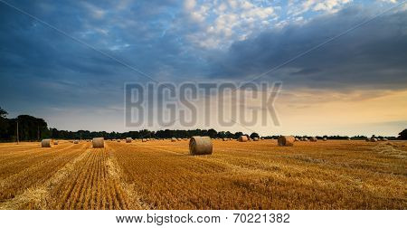 Rural Landscape Image Of Summer Sunset Over Field Of Hay Bales