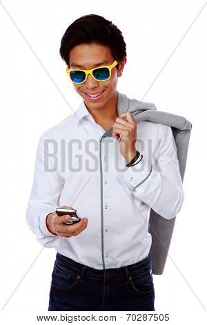 Fashion asian man in sunglasses using smarthone over white background