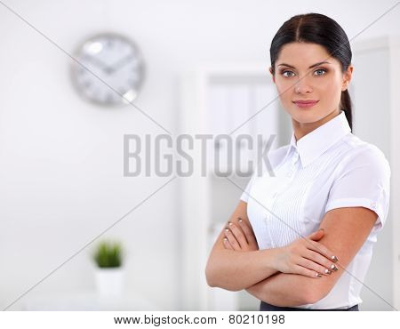 Attractive businesswoman with her arms crossed  standing in office
