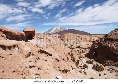 Volcanic rock and Ollague volcano in Atacama desert
