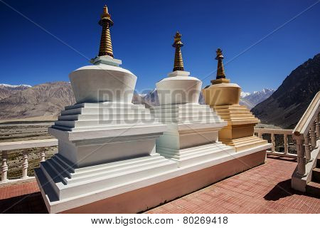 Three stupa and blue sky at Diskit monastery, Ladakh, India - September 2014