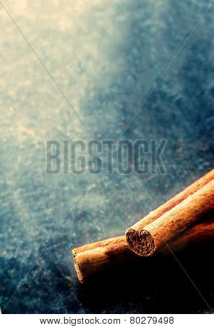 Cinnamon sticks close up on dark background with blank copyspace.