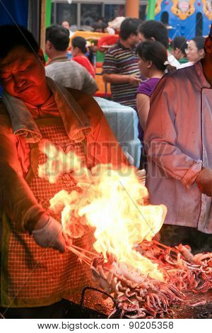 Man Frying Seafood On A Food Market In The Center Of Wuxi, Jiangsu Province, China