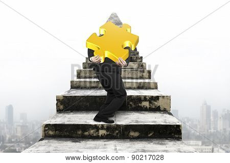 Businessman Carrying Gold Jigsaw Puzzle On Old Stairs With Cityscape