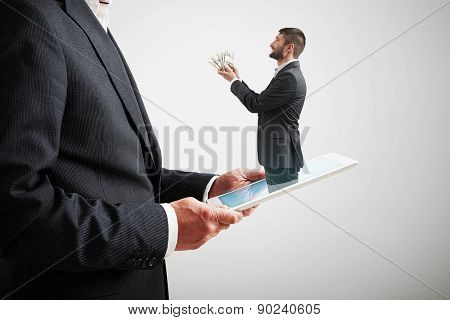 small smiley man got out of the tablet pc and offering money to the big man in formal wear over light grey background