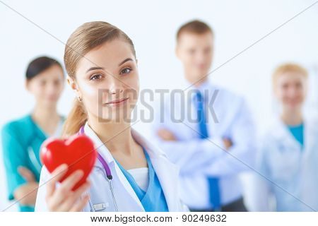 Female doctor with stethoscope holding heart .